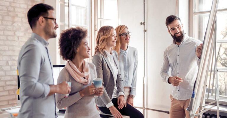 Führungskräfte im Austausch während einer Präsentation – Teamwork und Entwicklung im Rahmen eines INQA-Coachings.