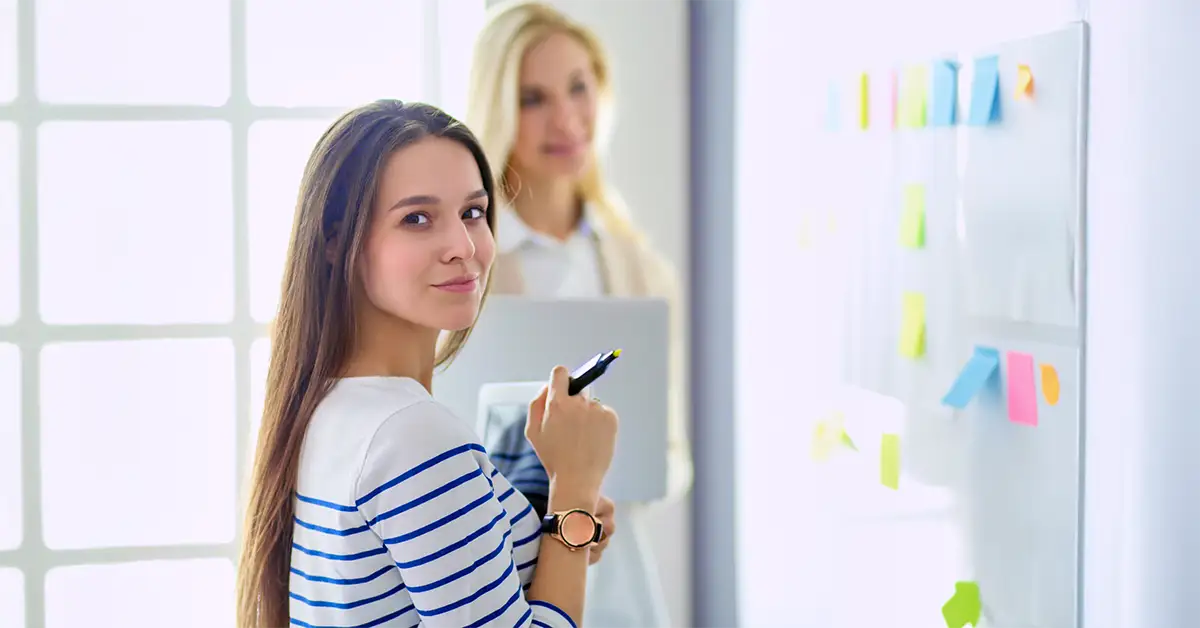 Junge Führungskraft bei der Teamplanung am Whiteboard – Führung lernen in der Praxis