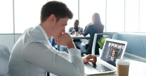 Eine junge Führungskraft folgt im Büro einem Meeting. Ein Beispiel für hybride Führung im Alltag.