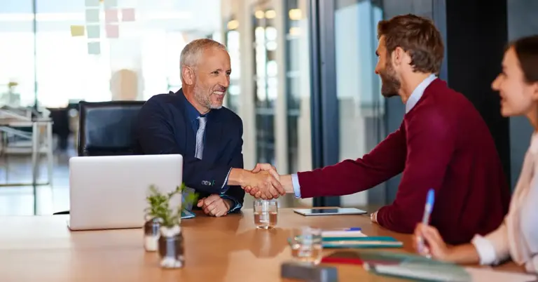 Führungskraft verhandelt mit Chef im Büro und bespricht berufliche Anliegen auf Augenhöhe.