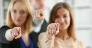 Drei Personen zeigen mit dem Finger direkt in die Kamera. Ein Symbol für negatives Feedback von Mitarbeitern, das sich häufig wie ein Fingerzeig anfühlt.