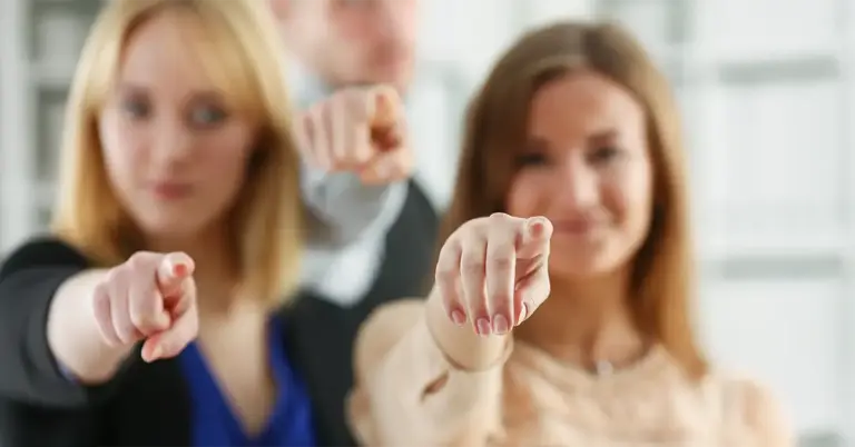 Drei Personen zeigen mit dem Finger direkt in die Kamera. Ein Symbol für negatives Feedback von Mitarbeitern, das sich häufig wie ein Fingerzeig anfühlt.